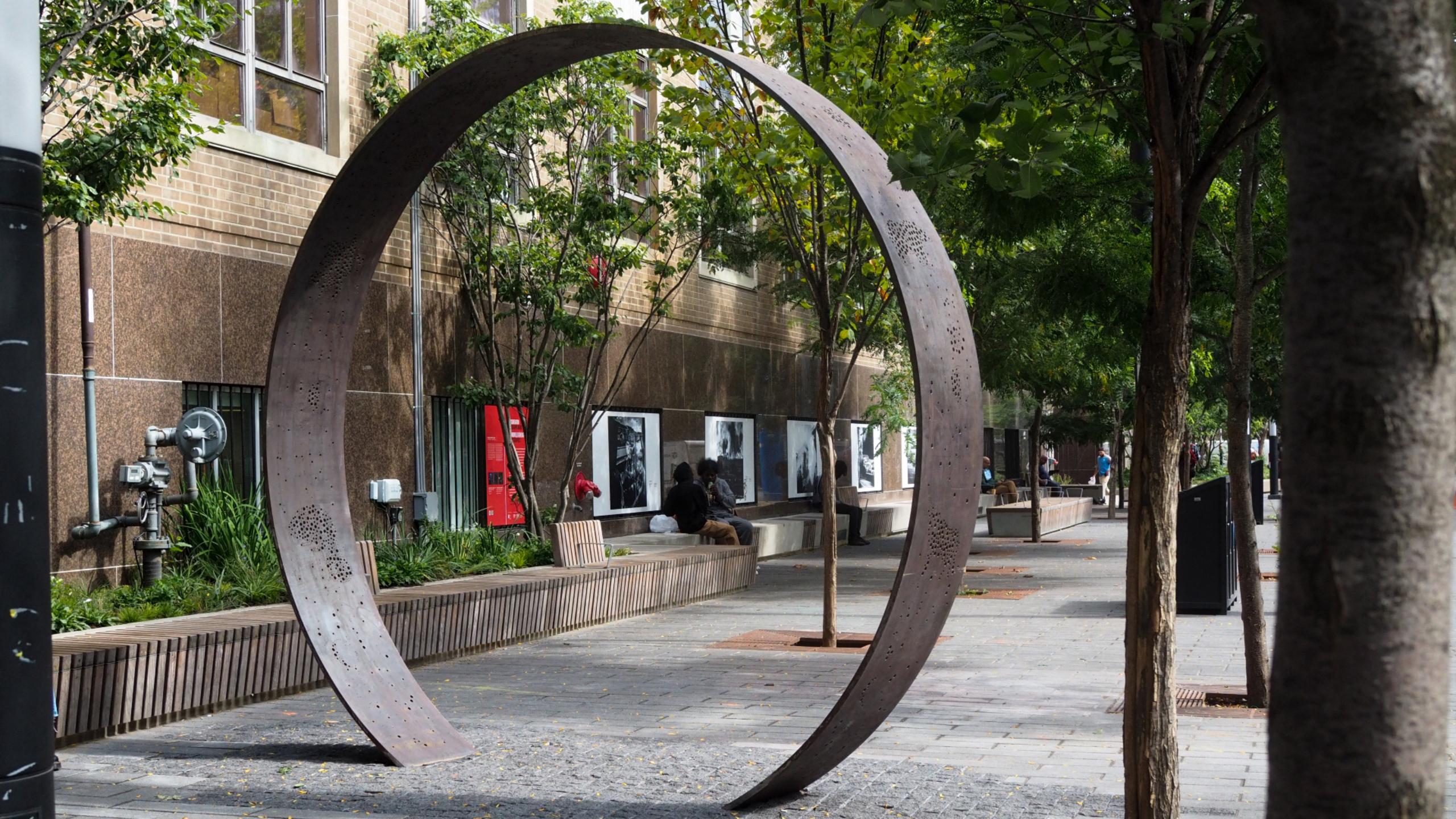 A monument beside a campus building in the shape of a circle