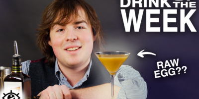 Jake MacAndrew leaning against a table with a martini glass in front of him. An arrow pointing to the glass with the caption “Raw egg?” Title reads: Drink of the week.