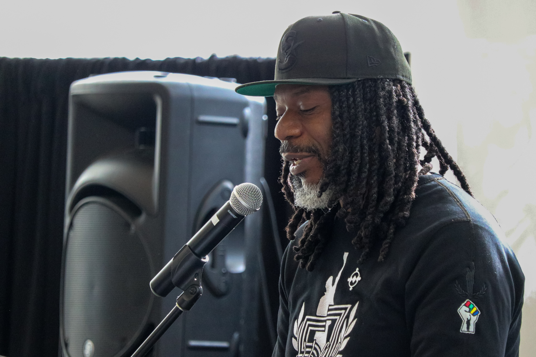 Mark Stoddard speaks while donning the new John Carlos inspired shirt he designed