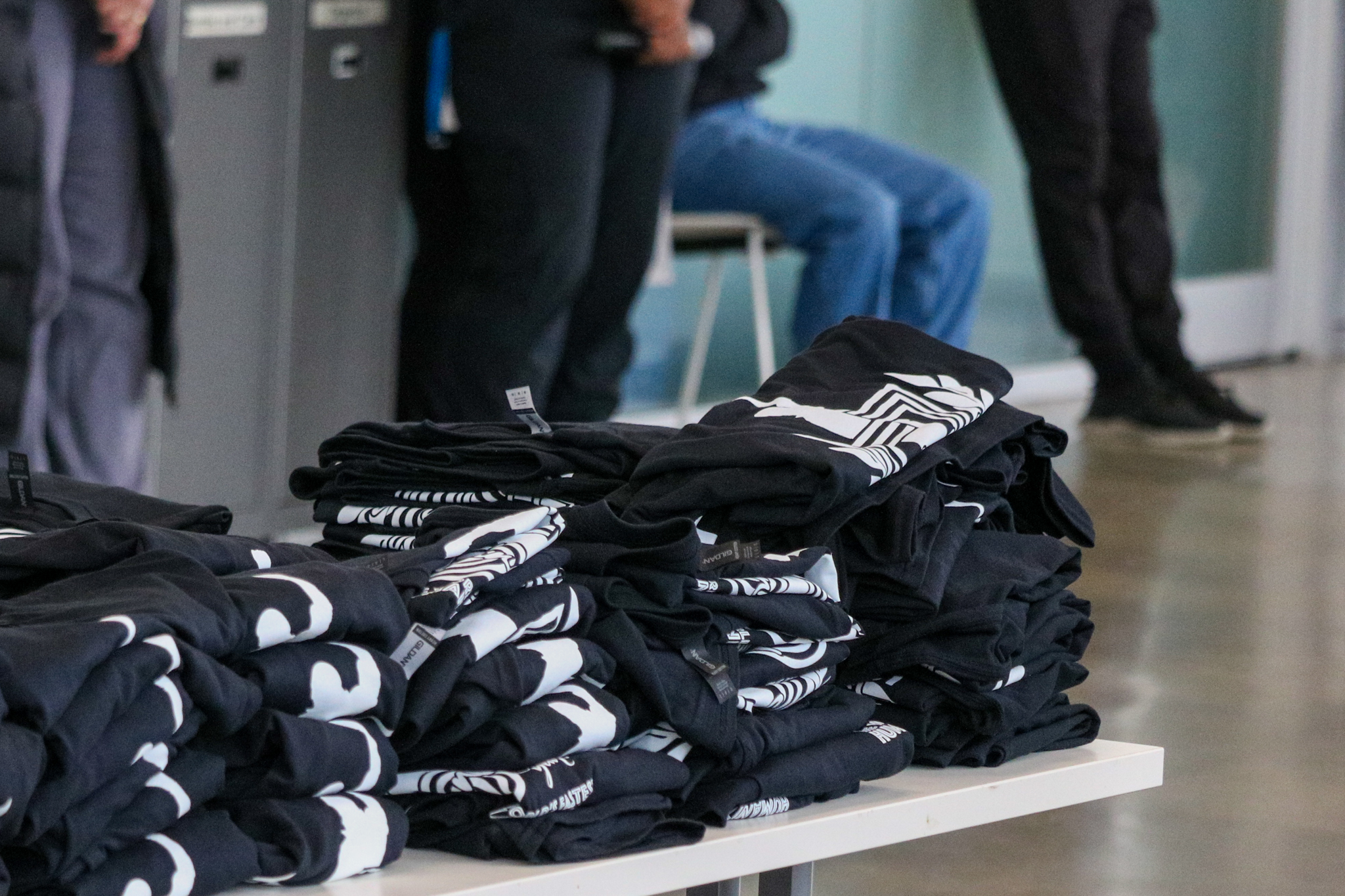 A stack of black t shirts on a table