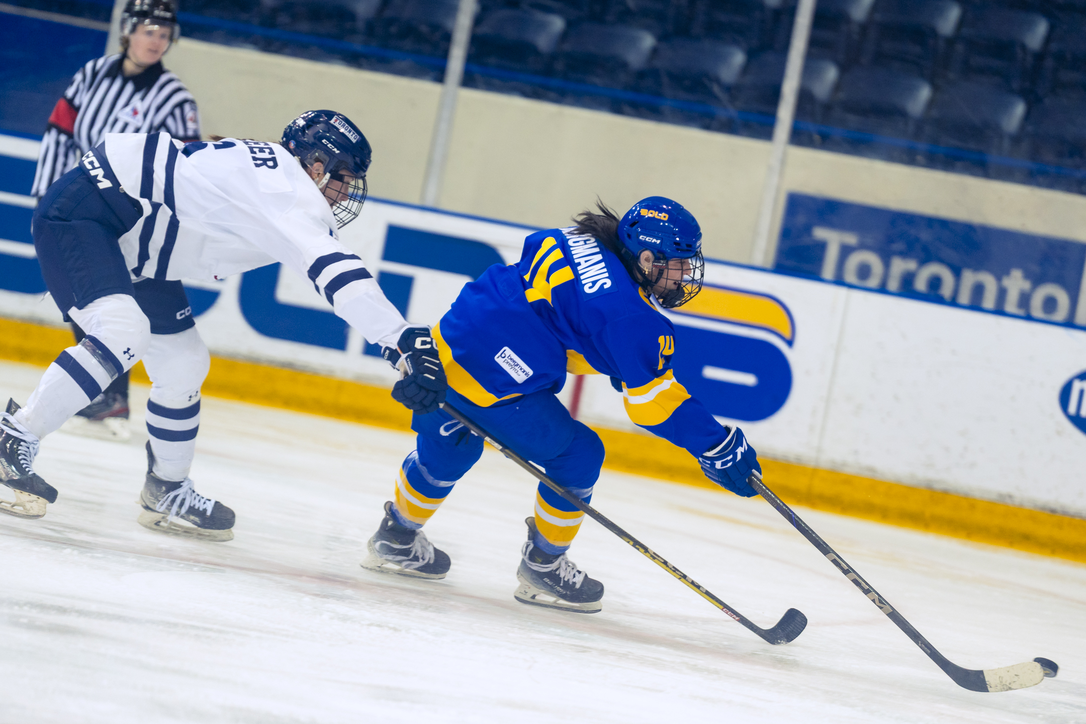 Megan Bergmanis outskates a reaching Varsity Blues defender and protects the puck